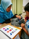 Colourful letters on the book as reference for the child to type into the braille typwriter