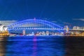 Colourful Light show at night on Sydney Harbour NSW Australia. The bridge illuminated with lasers and neon coloured lights