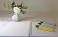 Colourful markers, notebook and flower.