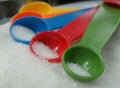 Colourful measuring spoons and white sugar