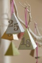 Colourful paper party decorations with the numbers eighteen and 25 with a silver finish, hanging on an painted white branch Royalty Free Stock Photo