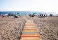 Colourful path on beach with sunbathers Royalty Free Stock Photo