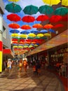 A colourful photo of umbrellas in a shopping arcade