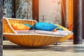 Colourful pillows on modern daybed. Brown rattan loungers with orange and blue pillows hanging with rope by relaxing terrace.