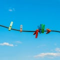 Colourful clothespins clothes pegs on outdoor wire laundry wash line against a vivid clear blue sky Royalty Free Stock Photo