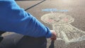 Rain chasing doll kid drawing with colourful pastel sidewalk chalks on the pavement