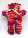 Colourful rainbow knitted teddy bear with ribbon scarf