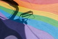 Colourful rainbow rubber floor on an outdoor amusement park with a strong shadow of a playing seat casted.