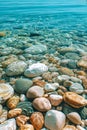 Colourful round sea pebbles in a blue sea. Royalty Free Stock Photo