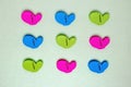 Colourful set of nine plastic clothespins or pegs on a light green sparkling background with copy field. View from abov