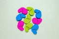 Colourful set of nine plastic clothespins or pegs on a light green sparkling background with copy field. View from abov