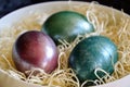 Colourful shiny easter eggs in the bowl with hay. Royalty Free Stock Photo