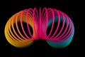 Colourful Slinky Spring Toy on a Black Background Top View Royalty Free Stock Photo