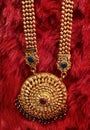 colourful stones golden necklace on red velvet background, Indian traditional jewellery