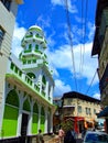 Colourful street scene - Lime Green and white Mosque and Minaret with bright blue sky Mombasa Kenya