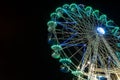 Colourful striped light illuminated spinning ferris wheel in motion moving at night Royalty Free Stock Photo