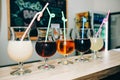 Colourful summer cocktails in glasses with straws. Drinks standing on the bar counter. Wine, pina colada and apple juice. Fresh Royalty Free Stock Photo