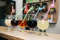 Colourful summer cocktails in glasses with straws. Drinks standing on the bar counter. Wine, pina colada and apple juice. Fresh Royalty Free Stock Photo