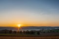 Colourful sunrise on a summer morning with a little fog on the ground and spectacular views over the Dutch hillside in Limburg