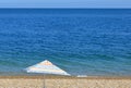 A Colourful Umbrella on a pebbled beach overlooking the ocean Royalty Free Stock Photo