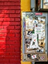 Colorful Urban Brick Building Exterior Wall with Electrical Box and Graffiti Stickers.