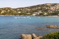 Colourful View looking at Cala Batistoni Beach and a Turquoise Mediteranean Ocean with Granite Coast and Pedalos: Baia Sardinia, G Royalty Free Stock Photo