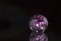 Colourful violet red white sphere on black background with reflection as modern abstract decorative healing object