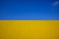 Colourful yellow rough finished wall against a blue skywith a cloud Royalty Free Stock Photo