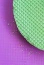 Colourfull green waffles on purple desk. Textured abstract background. Close up. Flat lay