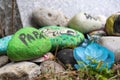 Colourfully Painted Rocks by a Grave