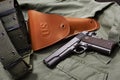 Colt gun pistol, holster and belt lie on military jacket