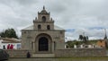 Group of indigenous people sitting in front of the church of Maria Natividad de Balbanera, the first Catholic church in Ecuador