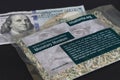 Close up of 100 Dollar Bill, and bag with shreds of unfit US currency.