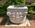 Column base with a relief of a medieval helmeted soldier carrying a club in a garden of the Cloisters in New York City. Royalty Free Stock Photo