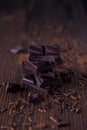 Column of dark or bitter or milk chocolate on a wood background Royalty Free Stock Photo