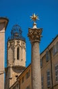 Column with golden star on top and bell tower in Aix-en-Provence. Royalty Free Stock Photo
