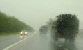 Column of modern military vehicles on the highway. Defocussed traffic viewed through a car windscreen covered in rain This is in