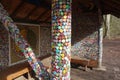 column in sun made of thousands of tiny colorful bottle tops . funny creative wall art in Grevenbroich, Germany .