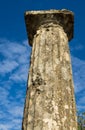 Column of white marble against the blue sky and clouds. Olympia, Peloponnes, Greece