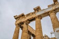 Columns of the ancient Greek Parthenon against a gray rainy sky