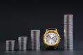 Columns of coins and clocks on a dark background. Time is money concept. Savings growth concept