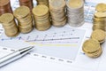 Columns of coins and pen on business chart Royalty Free Stock Photo