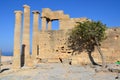 Columns on the hellenistic stoa of the Acropolis of Lindos, Rhodes, Greece, Blue sky, olive tree and beatiful sea view in the back Royalty Free Stock Photo