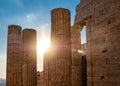 Columns of Propylaea gate entrance of Acropolis, Athens, Greece against blue sky and sun with sunrays coming through