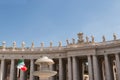 Columns, statues and an Italian flag waving in St Peter`s square, Rome, Italy on a sunny day Royalty Free Stock Photo