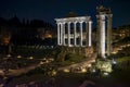 columns of the Temple of Saturn on the Palatine Hill illuminated at night with white light in the city of Rome.