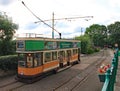 COLYTON, DEVON, ENGLAND - AUGUST 6TH 2012: An orange and green tram sits empty in Colyford station on the Seaton tramway