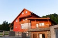 Wooden weekend cottage at sunset front view.