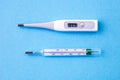 Comaprison of digital and analog thermometer on blue background Royalty Free Stock Photo
