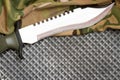 Combat knife on military camouflage fabric and metal background Royalty Free Stock Photo